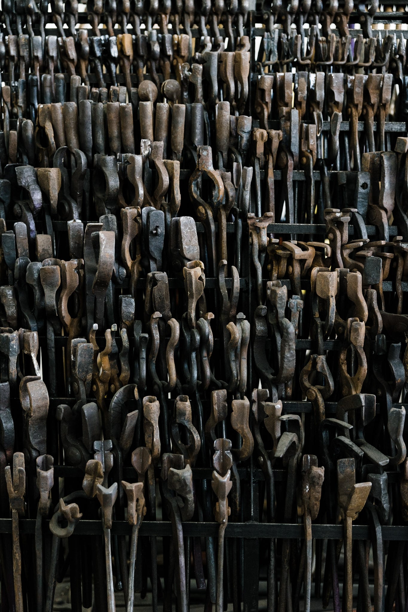 Blacksmithing tools lined up on racks at Adam's Forge in Los Angeles, CA