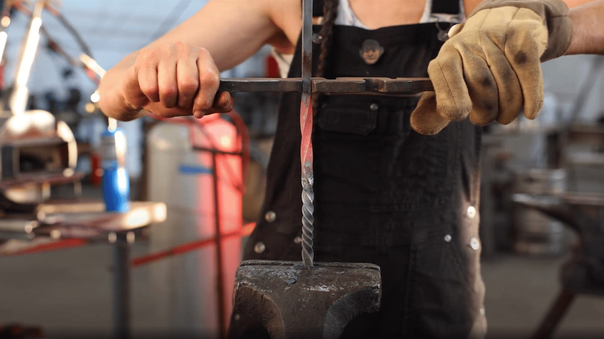 Heather McLarty demonstrating reverse twisting on a red-hot, forge-heated iron bar secured in a vise at Adam's Forge in Los Angeles, California. Photo by David Haskell.
