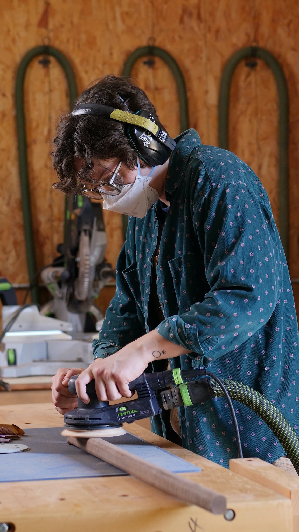 Lauren Verdugo sanding a walking cane with a random orbital sander at Maloof woodworking foundation in Alta Loma, California.