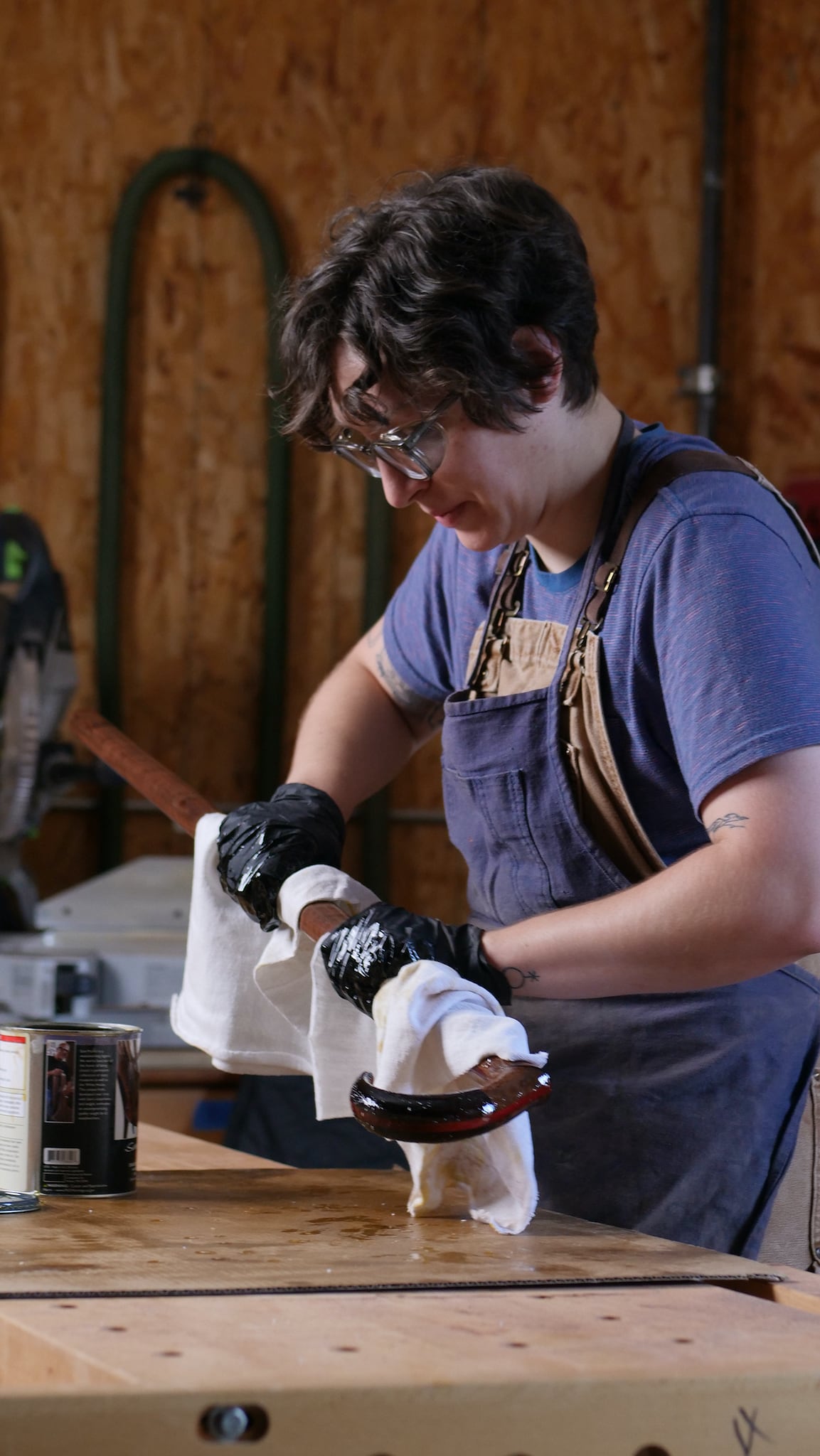 Lauren Verdugo varnishing a claro sage, ebony, wenge, and walnut walking cane at Maloof woodworking foundation in Alta Loma, California.